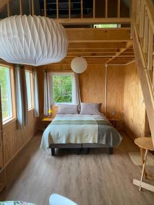 a bedroom with a large bed in a wooden room at Cabaña Raymapu in Puelo