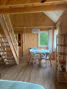 a dining room with a table and chairs and a staircase at Cabaña Raymapu in Puelo