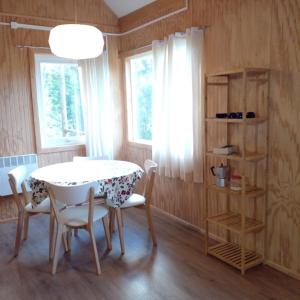 a dining room with a white table and chairs at Cabaña Raymapu in Puelo