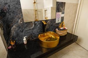a bathroom with a gold sink on a black counter at El Otel Hotel in Cairo
