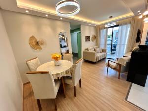 a dining room and living room with a table and chairs at Lunar Lua Nova 06 in Aracaju