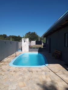 a swimming pool in a yard with a patio at Recanto Eucaliptos in Araçoiaba da Serra
