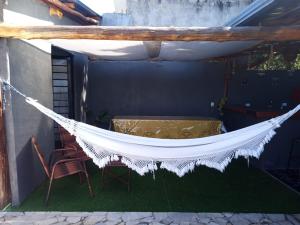 a hammock on a patio with a table and chairs at Recanto Eucaliptos in Araçoiaba da Serra