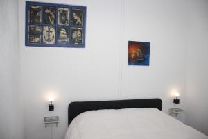 a bedroom with a bed and two pictures on the wall at Discoveries House Alenquer in Alenquer