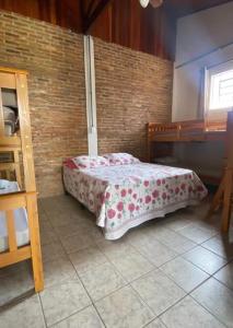 a bedroom with a bed and a brick wall at Casa de campo - chácara Guinato in Socorro +23 photos