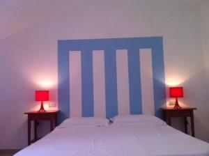 ヴィッラシミーウスにあるSul Mare Sardegna Villa Acteaのベッドルーム1室(青と白のベッド、ランプ2つ付)