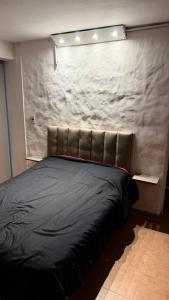 a black bed in a room with a wall at Casa Thompson in Paraná
