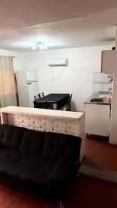 a living room with a black couch in a kitchen at Casa Thompson in Paraná