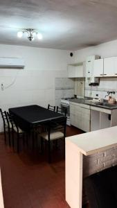 a kitchen with a black table and chairs in it at Casa Thompson in Paraná