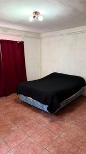 a bed in a room with a red curtain at Casa Thompson in Paraná +1 photo