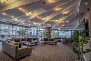 a large lobby with couches and tables and windows at saffari otel in Ankara
