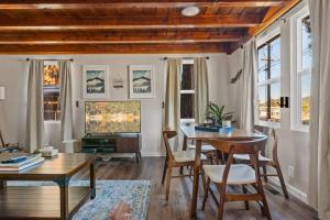 a living room with a table and chairs and windows at Bear Sky Cabin in Big Bear City