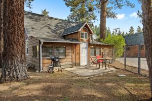 a small cabin with a grill and a table at Bear Sky Cabin in Big Bear City