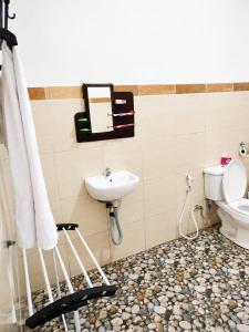 a bathroom with a toilet and a sink at Gosela Bali in Munduk