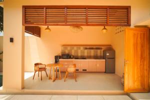 a kitchen with a table and chairs and a refrigerator at enn Collection in Kuta Lombok