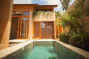 a house with a swimming pool in front of a house at enn Collection in Kuta Lombok
