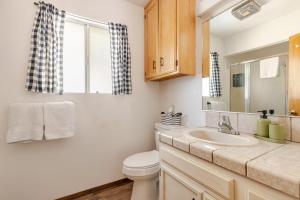 a bathroom with a sink and a toilet and a window at Peaceful Chalet in Oakhurst