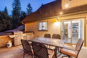 a patio with a table and chairs and a kitchen at Peaceful Chalet in Oakhurst