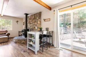 a living room with a stone wall and a table with chairs at Peaceful Chalet in Oakhurst +12 photos