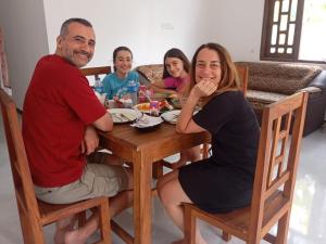 a group of people sitting around a wooden table at Ceylon Seaway Villa in Trincomalee +38 photos
