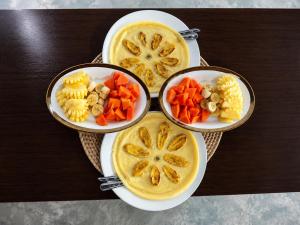 four bowls of food on a table with carrots and pasta at Bale Bangket Homestay in Tetebatu