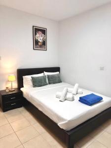 a bedroom with a large bed with white sheets and blue pillows at Arithea Hidden Seaside Heritage 2BR Suite in Paphos +16 photos