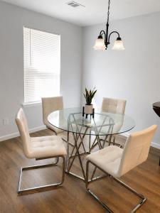 a dining room with a glass table and white chairs at Blue Haven Escape in Columbus