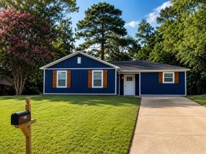 a blue house with a mailbox in a yard at Blue Haven Escape in Columbus