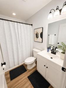 a white bathroom with a toilet and a sink at Blue Haven Escape in Columbus +3 photos