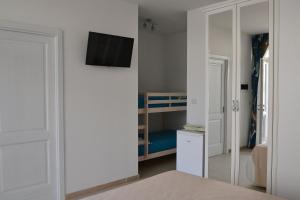 a small bedroom with a bunk bed and a tv on a wall at Dimora Porto Contessa in Polignano a Mare