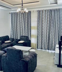 a living room with couches and a table and curtains at basalt&bamboo B&B in Ruhengeri +1 photo