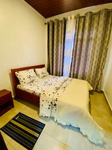a small bedroom with a bed and a window at basalt&bamboo B&B in Ruhengeri