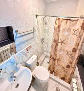 a bathroom with a toilet and a sink and a shower at Premium Yunusobod Hotel in Darkhon +8 photos