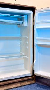 an empty refrigerator with its door open at Premium Yunusobod Hotel in Darkhon