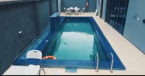 a large swimming pool with chairs and a table at Degrams Hotel and suites in Epe