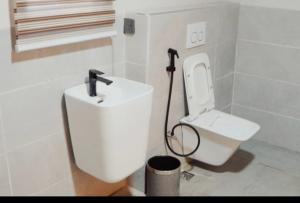 a bathroom with a white toilet and a sink at Degrams Hotel and suites in Epe +12 photos