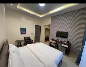 a bedroom with a bed and a desk and a television at Degrams Hotel and suites in Epe