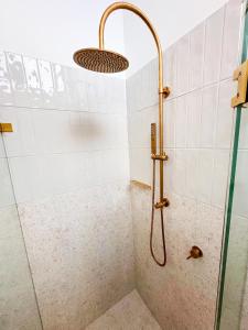 a shower with a shower head in a bathroom at Bateau Bay Hotel in Bateau Bay