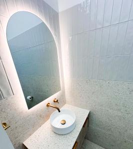a bathroom with a sink and a mirror at Bateau Bay Hotel in Bateau Bay