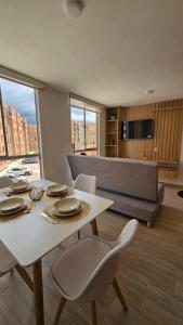 a living room with a table and chairs and a couch at Apartamento Urban Paipa in Paipa