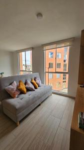 a living room with a couch with pillows on it at Apartamento Urban Paipa in Paipa