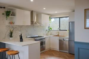 a kitchen with white cabinets and stainless steel appliances at La Villa Dolce in Mount Victoria
