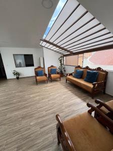 a large living room with couches and a large window at La Posada del Colibrí in Cuenca
