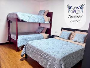 a bedroom with two bunk beds and a bed at La Posada del Colibrí in Cuenca +1 photo
