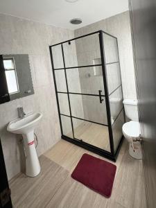 a bathroom with a glass shower and a toilet at La Posada del Colibrí in Cuenca