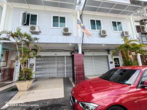 a red car parked in front of a house at Arkid 10 Guesthouse in Ipoh