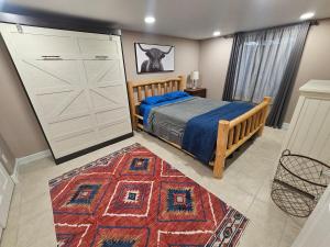 a bedroom with a bed and a rug and a closet at The Cottonwood Den in Laramie