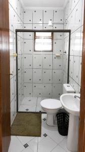 a white bathroom with a toilet and a sink at Apartamentos PraiaMar in Ilha Comprida +60 photos