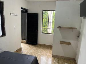 a room with a bed and a window and a door at Hotel Don Franco in Villagarzón