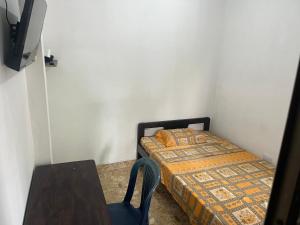 a small bedroom with a bed and a table at Hotel Don Franco in Villagarzón